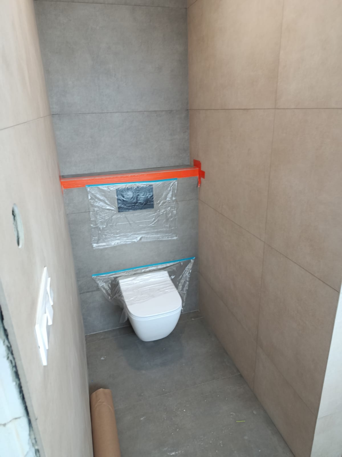 Závěsné WC v obložené kabině v šedé a béžové kombinaci