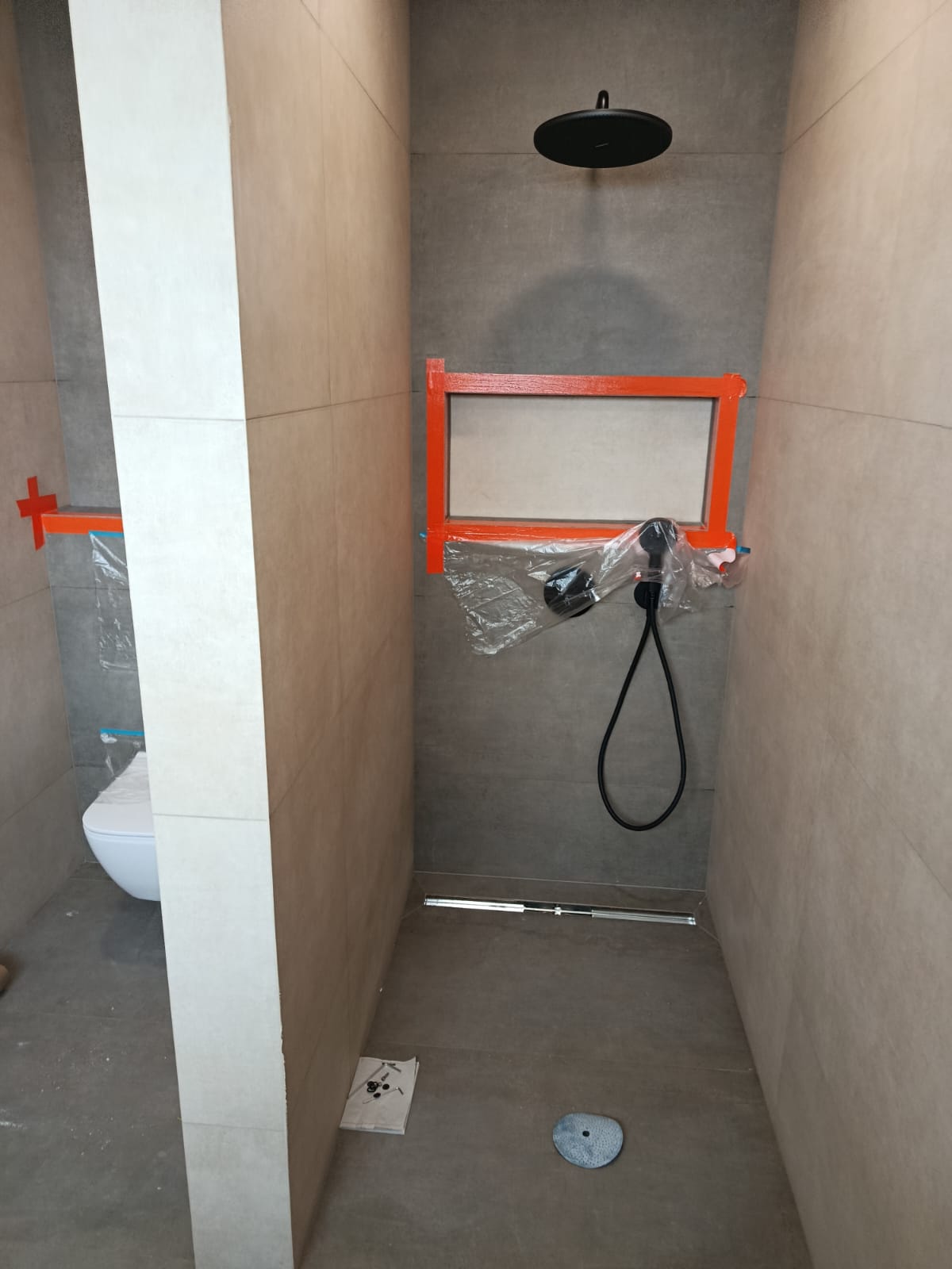 Walk-in sprcha s černou baterií a liniovým odtokovým žlabem